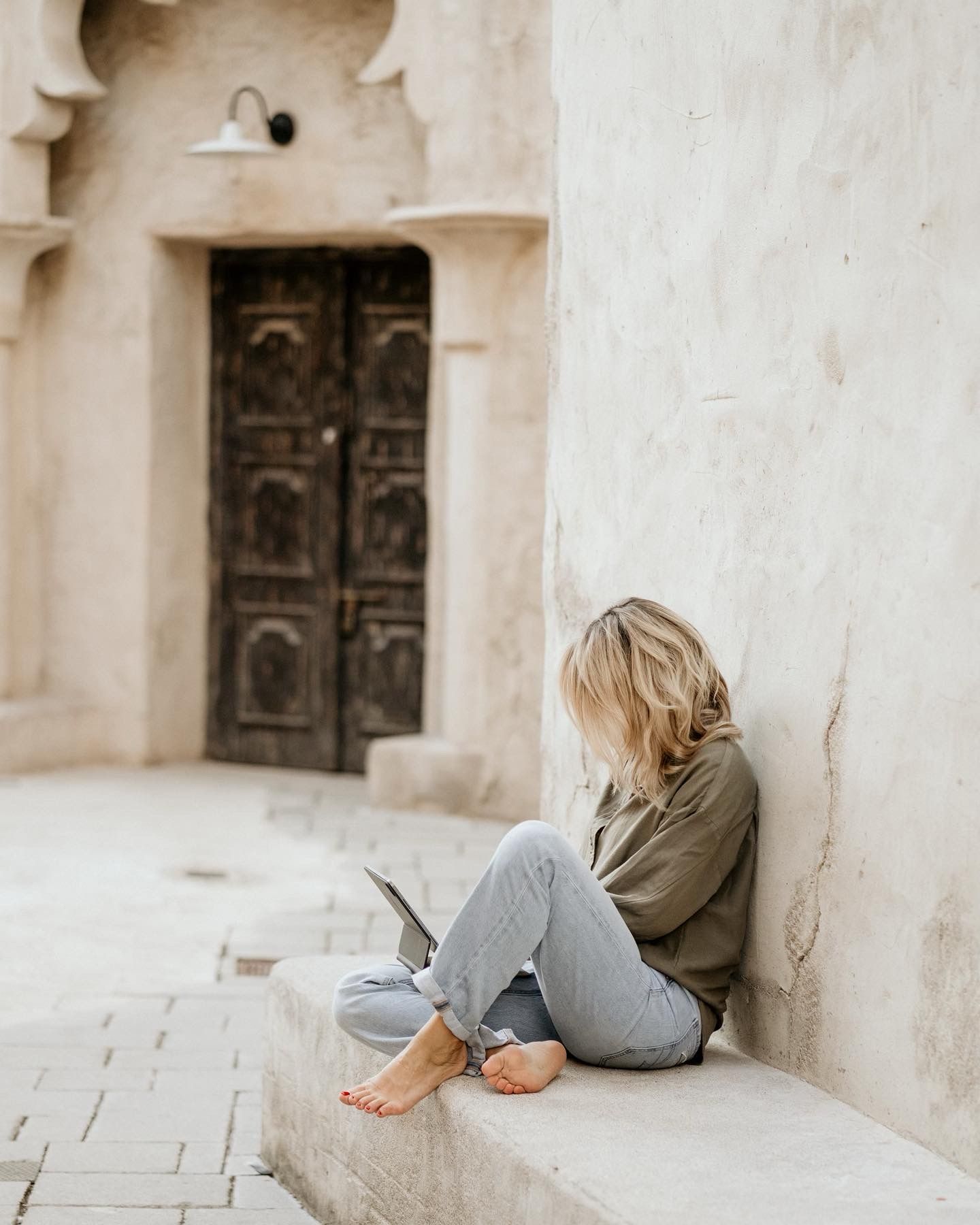 Carole Curty sitting in front of a door in Dubai